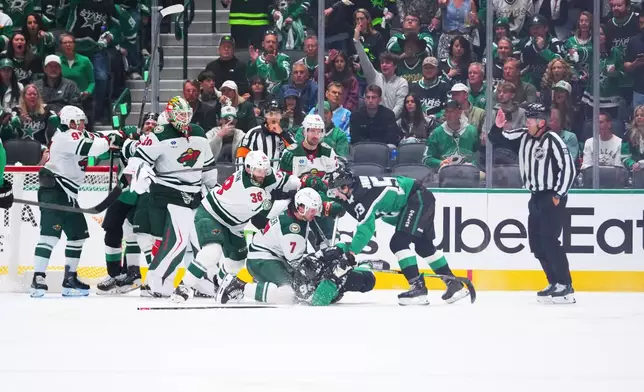 Dallas Stars right wing Mikko Rantanen (96) is dropped to the ice while scuffling with Minnesota Wild players during the second period in Game 1 of a first-round NHL Stanley Cup playoffs hockey series, Saturday, April 18, 2026, in Dallas, Texas. (AP Photo/Julio Cortez)