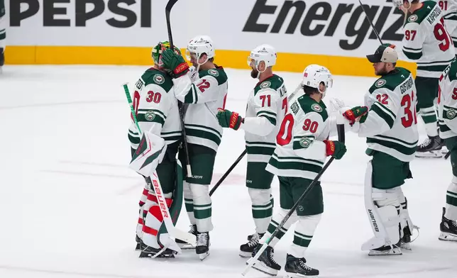 Minnesota Wild goaltender Jesper Wallstedt (30) reacts with left wing Matt Boldy (12) after defeating the Dallas Stars 6-1 in Game 1 of a first-round NHL Stanley Cup playoffs hockey series, Saturday, April 18, 2026, in Dallas, Texas. (AP Photo/Julio Cortez)