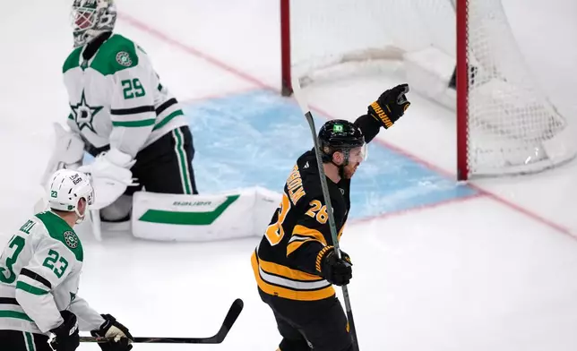 Boston Bruins center Elias Lindholm (28) celebrates after his goal against Dallas Stars goaltender Jake Oettinger, rear, during the third period of an NHL hockey game, Tuesday, March 31, 2026, in Boston. (AP Photo/Charles Krupa)