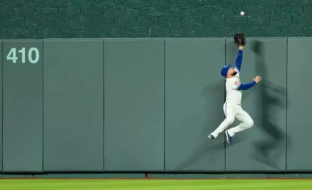 Kansas City Royals center fielder Kyle Isbel can't get to a grand slam hit by Baltimore Orioles' Leody Taveras during the 12th inning of a baseball game Monday, April 20, 2026, in Kansas City, Mo. (AP Photo/Charlie Riedel)