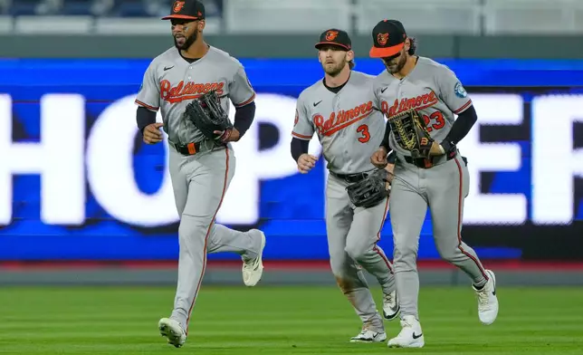 Baltimore Orioles outfielders Leody Taveras, left, Taylor Ward (3) and Blaze Alexander, right, run off the field after their baseball game against the Kansas City Royals, Monday, April 20, 2026, in Kansas City, Mo. (AP Photo/Charlie Riedel)