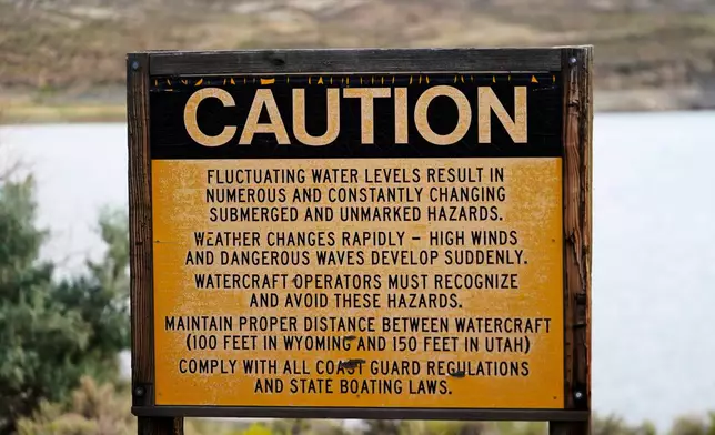 FILE - A sign cautioning fluctuating water levels is displayed at Firehole Canyon, on the far northeastern shore of Flaming Gorge Reservoir, Friday, Aug. 5, 2022, in Wyoming. (AP Photo/Rick Bowmer, File)