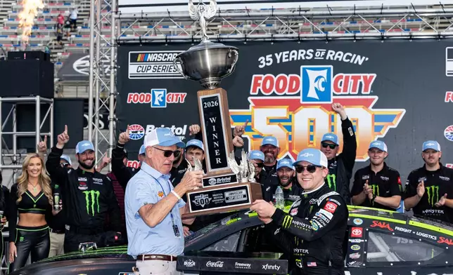 Ty Gibbs, front right, celebrates with the trophy after winning a NASCAR Cup Series auto race as he and Steve Smith, president and CEO of Food City hoist the trophy, Sunday, April 12, 2026, in Bristol, Tenn. (AP Photo/Wade Payne)