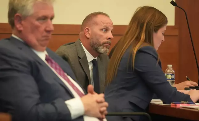 Jason Meade, center, sits with his attorneys Mark Collins, left, and Kaitlyn Stephens, right, during opening statements in the retrial of the former Ohio sheriff's deputy charged with murder and reckless homicide in the 2020 killing of Casey Goodson Jr., inside Franklin County Common Pleas Court in Columbus, Ohio, Thursday, April 23, 2026. (Doral Chenoweth/Pool photo via AP)