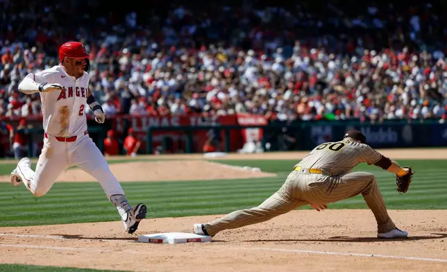 Los Angeles Angels' Mike Trout, left, runs to first base as San Diego Padres first baseman Gavin Sheets, right, catches the ball during the sixth inning of a baseball game Sunday, April 19, 2026, in Anaheim, Calif. (AP Photo/Caroline Brehman)