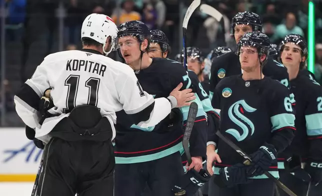 The Seattle Kraken, including center Bobby McMann, line up to greet Los Angeles Kings center Anze Kopitar (11) after a Kings win in an NHL hockey game Monday, April 13, 2026, in Seattle. (AP Photo/Lindsey Wasson)
