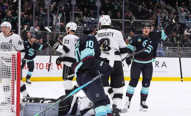 Seattle Kraken center Bobby McMann, right, celebrates scoring against the Los Angeles Kings during the third period of an NHL hockey game Monday, April 13, 2026, in Seattle. (AP Photo/Lindsey Wasson)