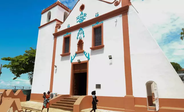 People walk by the Church of Our Lady of Muxima in Muxima, Angola, Saturday, April 11, 2026, which Pope Leo XIV will visit during his 11-day pastoral visit to Africa. (AP Photo)
