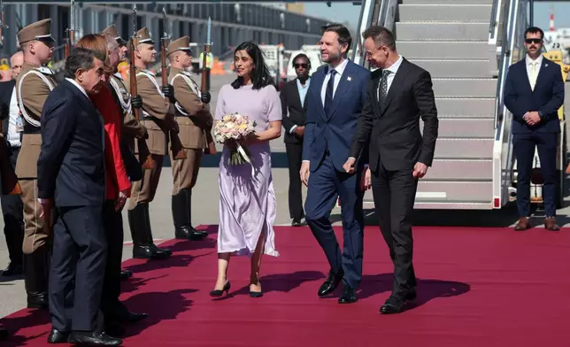 Hungarian Foreign Minister Peter Szijjarto, right, welcomes U.S. Vice President JD Vance, center, and second lady Usha Vance as they arrive at Budapest Ferenc Liszt International Airport in Budapest, Hungary Tuesday, April 7, 2026. (Jonathan Ernst/Pool Photo via AP)