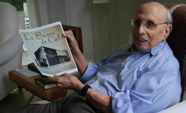 Raul Valdes-Fauli holds a picture of the family-owned Pedroso Bank in Havana during an interview Tuesday, April 21, 2026, in Coral Gables, Fla. (AP Photo/Marta Lavandier)
