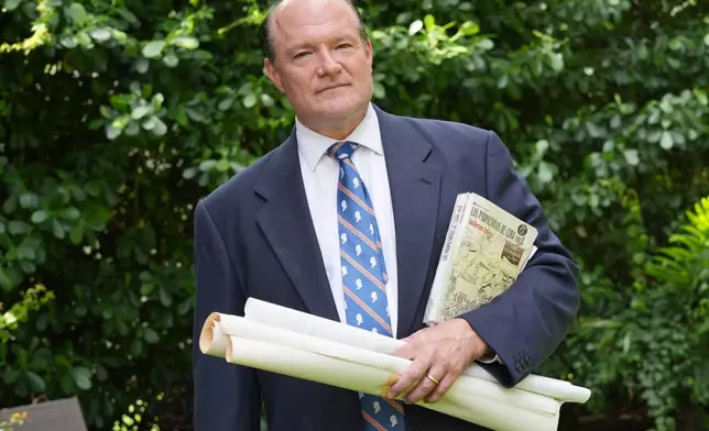 Nick Gutiérrez, President of the National Association of Cuban Landowners in Exile, holds architecture renderings of stolen properties by the Cuban government, Tuesday, April 21, 2026, in Coral Gables, Fla. (AP Photo/Marta Lavandier)