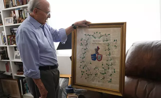 Raul Valdes-Fauli holds a genealogical chart showing his family's history in Cuba dating back to colonial times Tuesday, April 21, 2026, in Coral Gables, Fla. (AP Photo/Marta Lavandier)