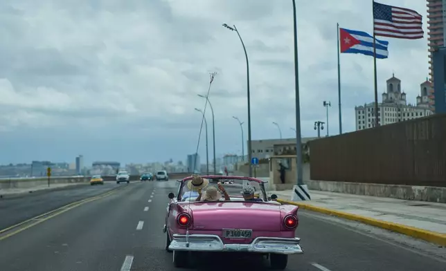 A classic American car carryies tourists past the U.S. Embassy in Havana, Monday, April 20, 2026. (AP Photo/Ramon Espinosa)