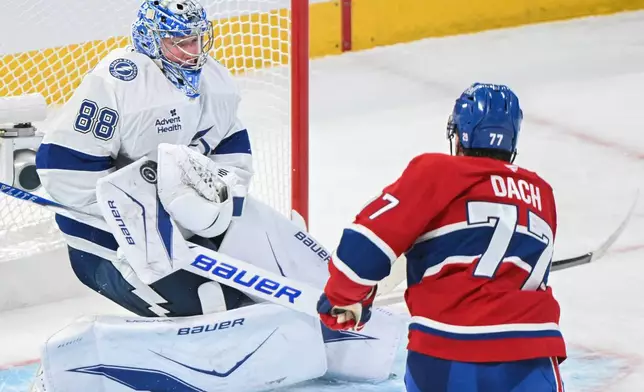 Tampa Bay Lightning goaltender Andrei Vasilevskiy (88) makes a save against Montreal Canadiens' Kirby Dach (77) during the second period of Game 3 in a first-round NHL hockey Stanley Cup playoff series in Montreal, Friday, April 24, 2026. (Graham Hughes/The Canadian Press via AP)
