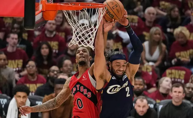 Cleveland Cavaliers guard Max Strus (2) grabs a rebound next to Toronto Raptors guard A.J. Lawson (0) in the first half in Game 2 of a first-round NBA basketball playoffs series in Cleveland, Monday, April 20, 2026. (AP Photo/Sue Ogrocki)