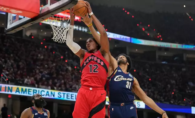 Toronto Raptors forward Collin Murray-Boyles (12) grabs a rebound next to Cleveland Cavaliers center Jarrett Allen (31) in the first half in Game 2 of a first-round NBA basketball playoffs series in Cleveland, Monday, April 20, 2026. (AP Photo/Sue Ogrocki)