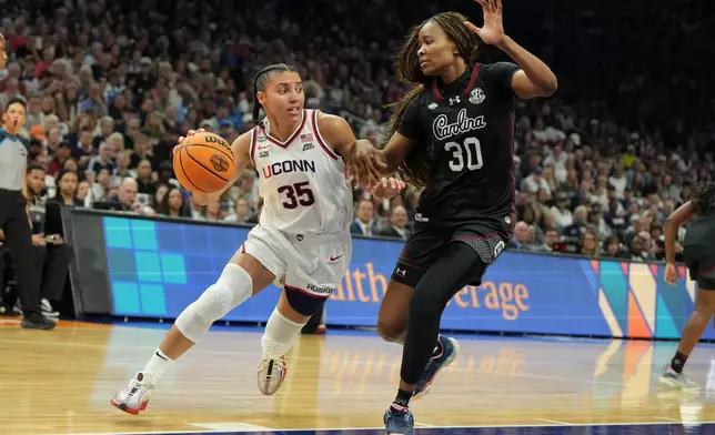 UConn guard Azzi Fudd (35) drives against South Carolina forward Maryam Dauda (30) during the first half of a woman's NCAA college basketball tournament semifinal game at the Final Four, Friday, April 3, 2026, in Phoenix. (AP Photo/Rick Scuteri)