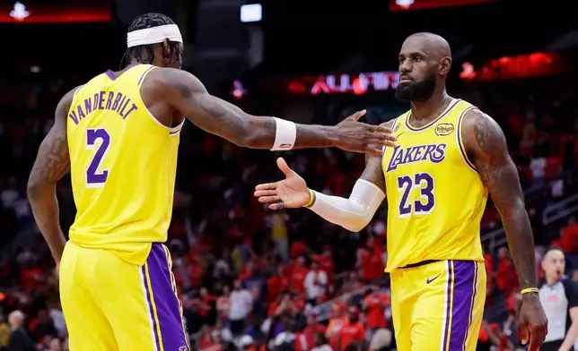 Los Angeles Lakers forwards Jarred Vanderbilt (2) and LeBron James (23) celebrate after their overtime win against the Houston Rockets in Game 3 of a first-round NBA playoffs basketball series Friday April 24, 2026, in Houston. (AP Photo/Michael Wyke)