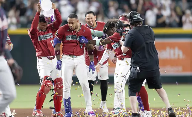 Arizona Diamondbacks teammates celebrate Ketel Marte's (4) game-winning home run in the 10th inning of a baseball game against the Atlanta Braves, Sunday, April 5, 2026, in Phoenix. (AP Photo/Rebecca Noble)