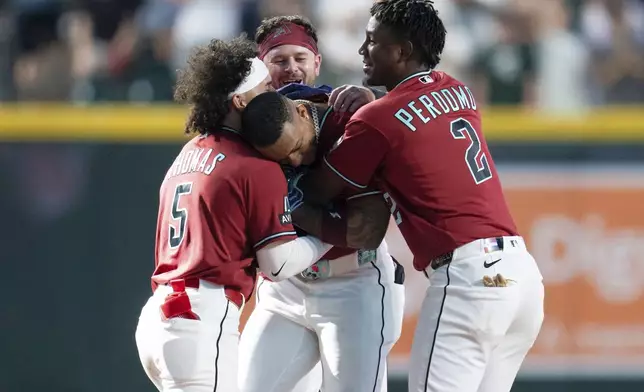 Arizona Diamondbacks teammates celebrate second baseman Ketel Marte's game-winning home run in the 10th inning of a baseball game against the Atlanta Braves, Sunday, April 5, 2026, in Phoenix. (AP Photo/Rebecca Noble)