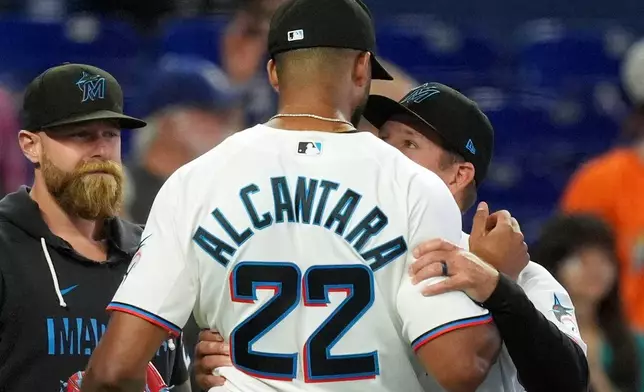 Miami Marlins manager Clayton McCullough, right, embraces starting pitcher Sandy Alcantara after he pitched the entirety of a baseball game against the Chicago White Sox, Wednesday, April 1, 2026, in Miami. (AP Photo/Rebecca Blackwell)