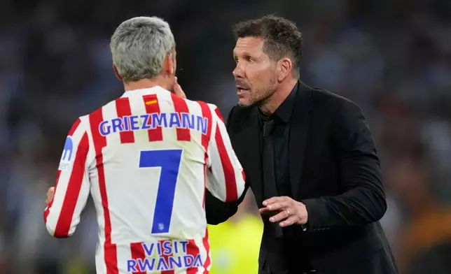 Atletico Madrid's head coach Diego Simeone, right, talks with Antoine Griezmann during the Copa del Rey final soccer match between Atletico Madrid and Real Sociedad in Seville, Spain, Saturday, April. 18, 2026. (AP Photo/Jose Breton)