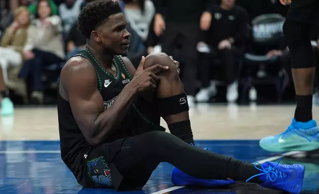 Minnesota Timberwolves guard Anthony Edwards grabs his knee after an injury during the first half of Game 4 of a first-round NBA basketball playoff series against the Denver Nuggets, Saturday, April 25, 2026, in Minneapolis. (AP Photo/Abbie Parr)