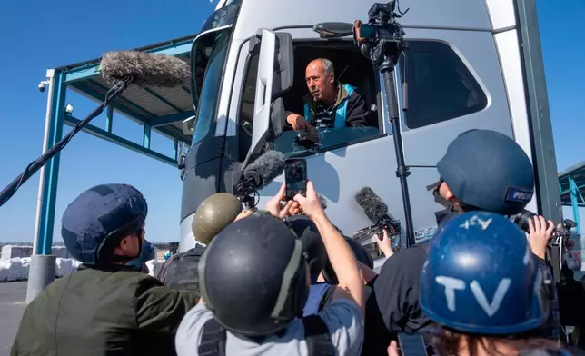 FILE - A truck driver picks up humanitarian aid designated for Gaza, as reporters tour the Palestinian side of the Kerem Shalom crossing where aid is awaiting pickup, on Dec. 19, 2024. (AP Photo/Ohad Zwigenberg, File)