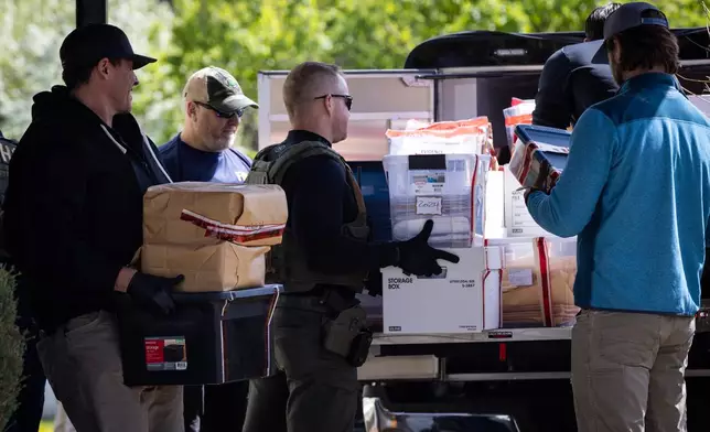 Federal and state officials load evidence into a vehicle as they execute a search warrant at The Original Childcare Center in south Minneapolis, Tuesday, April 28, 2026. (Ben Hovland/Minnesota Public Radio via AP)