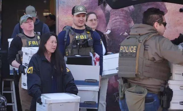 State and federal agents remove boxes of evidence collected from Metro Learning Center on Tuesday, April 28, 2026 in Minneapolis, Minn. (AP Photo/Mark Vancleave)