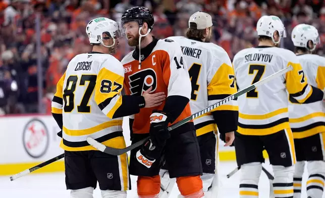 Philadelphia Flyers' Sean Couturier (14) and Pittsburgh Penguins' Sidney Crosby (87) meet after the Flyers won Game 6 in the first round of the NHL hockey Stanley Cup playoffs series Wednesday, April 29, 2026, in Philadelphia. (AP Photo/Matt Slocum)