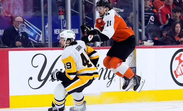 Philadelphia Flyers' Travis Konecny, right, leaps past Pittsburgh Penguins' Samuel Girard during the second period of Game 6 in the first round of the NHL hockey Stanley Cup playoffs series Wednesday, April 29, 2026, in Philadelphia. (AP Photo/Matt Slocum)
