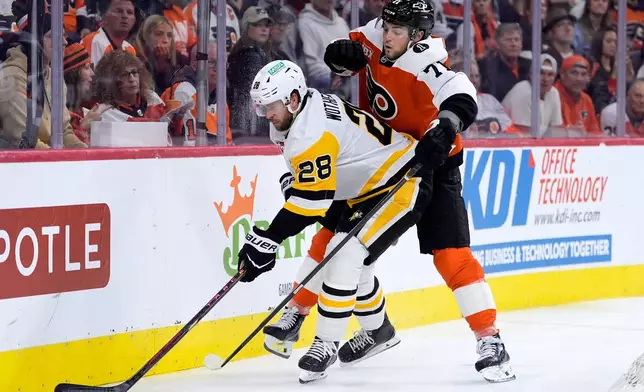 Pittsburgh Penguins' Parker Wotherspoon, left, tries to keep the puck away from Philadelphia Flyers' Tyson Foerster during the second period of Game 6 in the first round of the NHL hockey Stanley Cup playoffs series Wednesday, April 29, 2026, in Philadelphia. (AP Photo/Matt Slocum)