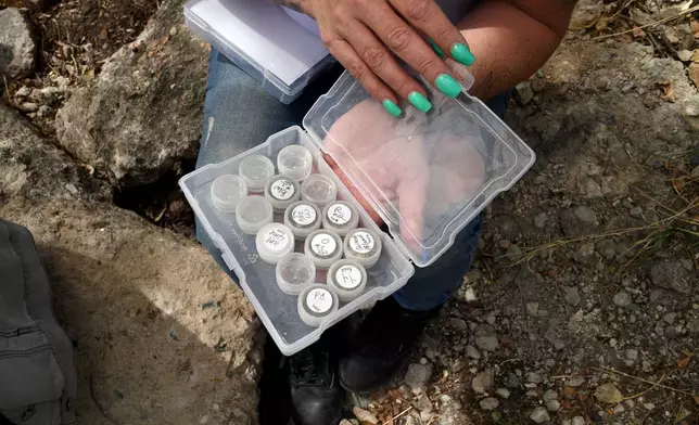 Crystina Page, whose son's body was among nearly 200 found decomposing in a southern Colorado funeral home in 2023, holds samples of fake ashes that were given to families instead of human remains, at a memorial site in Colorado Springs, Colo., on Wednesday, April 22, 2026. (AP Photo/Thomas Peipert)