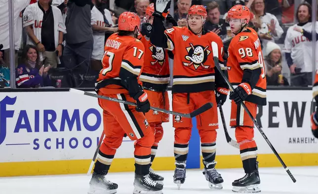 Anaheim Ducks defenseman John Carlson, second from right, celebrates with left wing Alex Killorn (17), right wing Beckett Sennecke, second from left, and defenseman Pavel Mintyukov (98)t, after scoring during the first period of an NHL hockey game against the San Jose Sharks, Thursday, April 9, 2026, in Anaheim, Calif. (AP Photo/Ryan Sun)