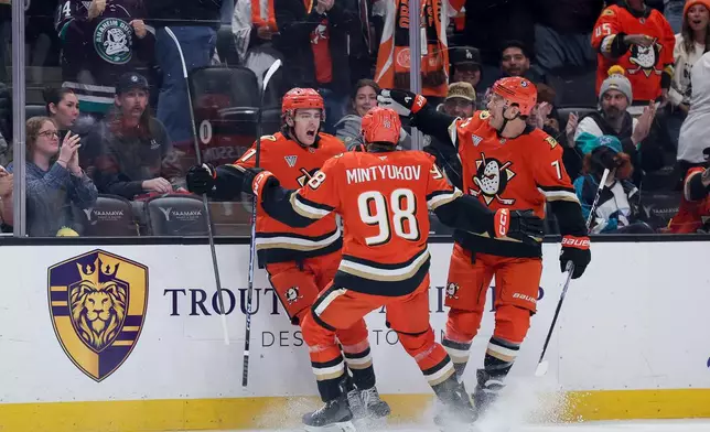 Anaheim Ducks center Leo Carlsson, left, celebrates with defenseman Pavel Mintyukov, center, and defenseman John Carlson after scoring during the first period of an NHL hockey game against the San Jose Sharks Thursday, April 9, 2026 in Anaheim, Calif. (AP Photo/Ryan Sun)