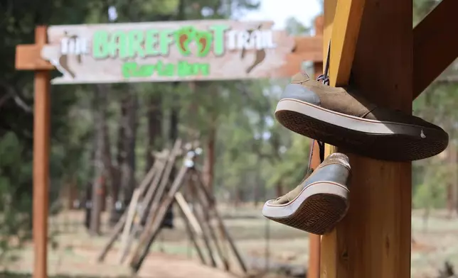 Shoes hang near the entrance of a barefoot trail near Flagstaff, Ariz, on Thursday, April 16, 2026. (AP Photo/Cheyanne Mumphrey)