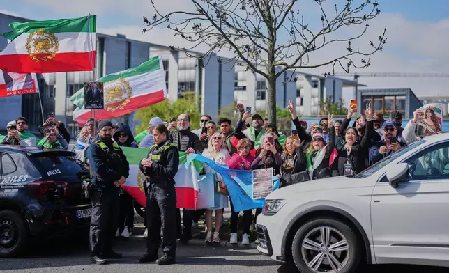 Supporters of Reza Pahlavi, exiled son of Shah Reza Pahlavi, shout slogans outside the building where Pahlavi holds a news conference in Berlin, Germany, Thursday, April 23, 2026. (AP Photo/Markus Schreiber)