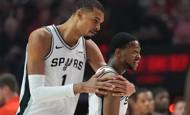 San Antonio Spurs forward/center Victor Wembanyama (1) reacts with guard De'aaron Fox after aplay during the first half in Game 4 of a first-round NBA basketball playoffs series against the Portland Trail Blazers, in Portland, Ore., Sunday, April 26, 2026. (AP Photo/Jenny Kane)