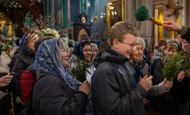 A Lithuanian Orthodox priest blesses believers during the Palm Sunday Mass at the Orthodox Church of the Holy Spirit in Vilnius, Lithuania, Sunday, April 5, 2026. (AP Photo/Mindaugas Kulbis)