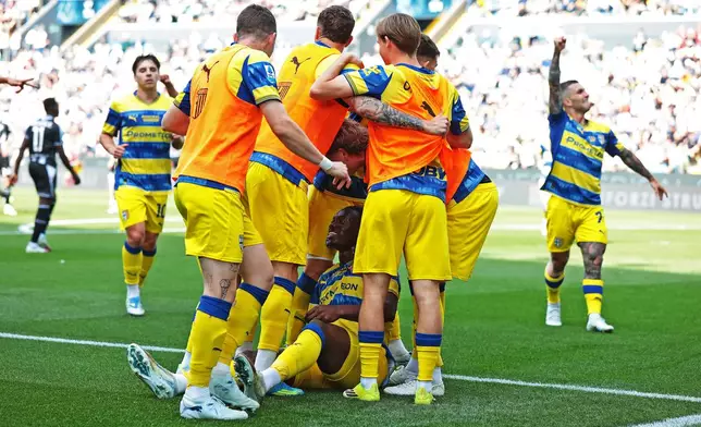Parma's Nesta Elphege, center, celebrates scoring their side's first goal of the game with teammates during the Italian Serie A soccer match between Udinese and Parma in Udine, Italy, Saturday, April 18, 2026. (Andrea Bressanutti/LaPresse via AP)