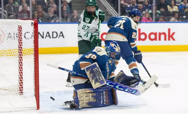 Boston Fleet's Shay Maloney (27) and Vancouver Goldeneyes' Ashton Bell (21) battle in front as the puck goes in the net past goalie Emerance Maschmeyer (38) during second period PWHL hockey action in Edmonton on Tuesday, April 7, 2026. (Jason Franson/The Canadian Press via AP)