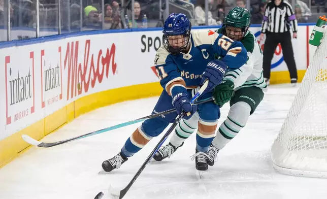 Boston Fleet's Shay Maloney (27) and Vancouver Goldeneyes' Ashton Bell (21) battle for the puck during second period PWHL hockey action in Edmonton on Tuesday, April 7, 2026. (Jason Franson/The Canadian Press via AP)