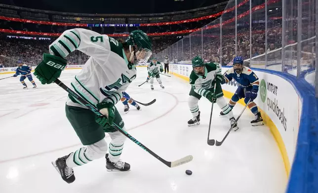 Boston Fleet's Megan Keller (5), Abby Newhook (19) and Vancouver Goldeneyes' Sydney Bard (11) battle for the puck during the first period of a PWHL hockey game in Edmonton on Tuesday, April 7, 2026. (Jason Franson/The Canadian Press via AP)