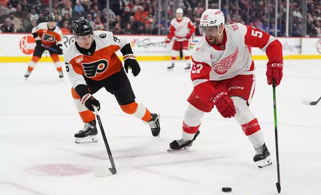 Detroit Red Wings' David Perron (57) tries to skate past Philadelphia Flyers' Emil Andrae, front left, during the first period of an NHL hockey game, Thursday, April 2, 2026, in Philadelphia. (AP Photo/Matt Rourke)