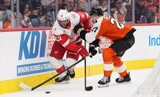 Philadelphia Flyers' Noah Cates, right, and Detroit Red Wings' David Perron, left, battle for the puck during the first period of an NHL hockey game, Thursday, April 2, 2026, in Philadelphia. (AP Photo/Matt Rourke)