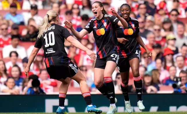 OL Lyonnes' Jule Brand, center, celebrates after scoring the opening goal during the Women's Champions League semi-final, first leg soccer match between Arsenal and OL Lyonnes in London, England, Sunday April 26, 2026. (Andrew Matthews/PA via AP)