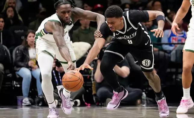 Brooklyn Nets forward E.J. Liddell (9) fights for control of the ball with Milwaukee Bucks forward Taurean Prince (12) during the first half of an NBA basketball game, Tuesday, April 7, 2026, in New York. (AP Photo/Yuki Iwamura)