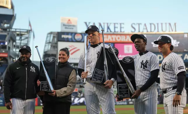 New York Yankees coaches and players including outfielder Aaron Judge, center, and second baseman Jazz Chisholm Jr., center right, receive their Silver Slugger awards before a baseball game against the Athletics, Wednesday, April 8, 2026, in New York. (AP Photo/Heather Khalifa)