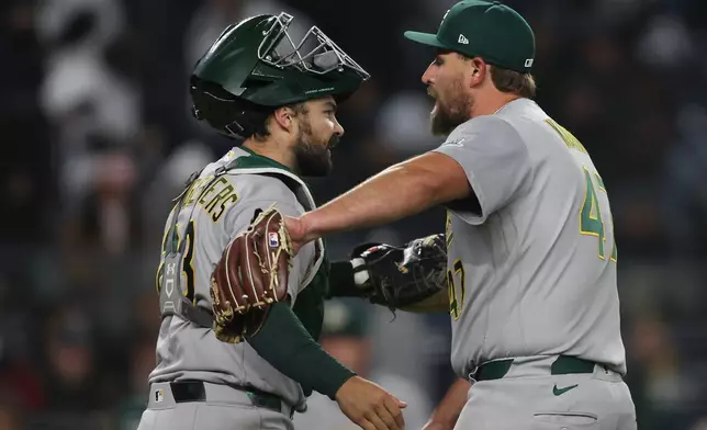 Athletics catcher Shea Langeliers, left, and pitcher Joel Kuhnel celebrate a win after the ninth inning of a baseball game against the New York Yankees, Wednesday, April 8, 2026, in New York. (AP Photo/Heather Khalifa)
